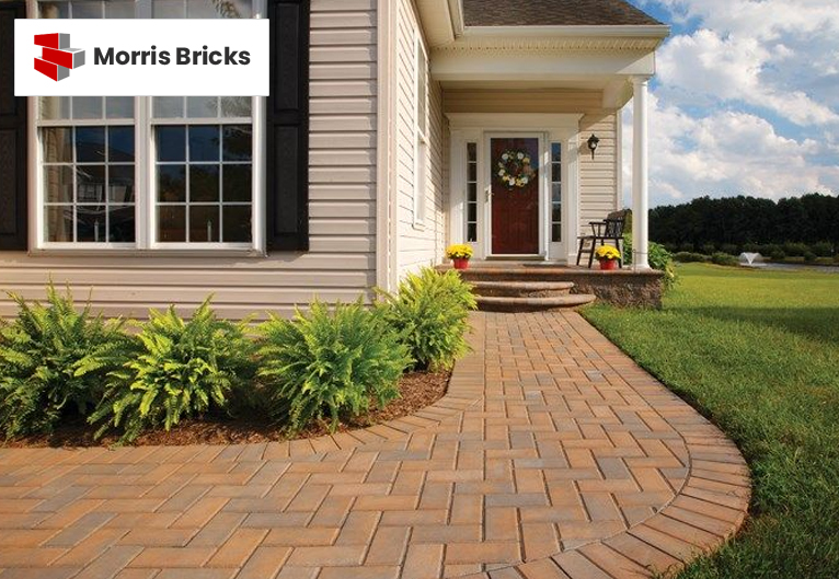 Modern paver walkway with brick-style patterns surrounded by greenery.